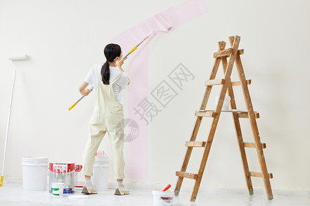 劳作的背影努力粉刷墙面的女性背影背景