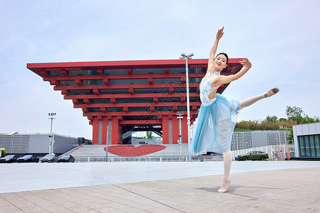 红色建筑物前舞蹈的女性高清图片