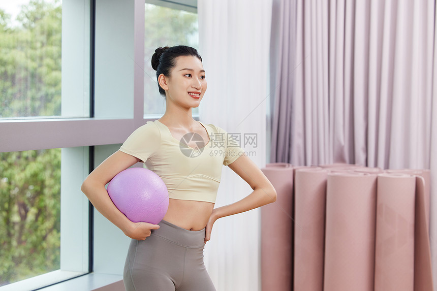 运动女生抱着紫色瑜伽小球图片