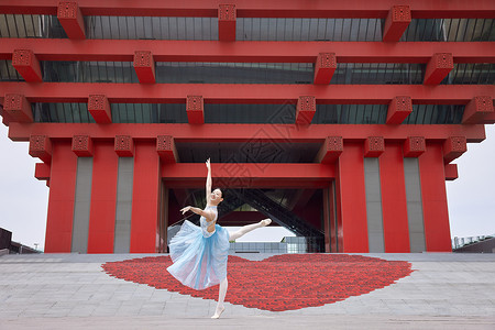 红色建筑前舞蹈的女性图片