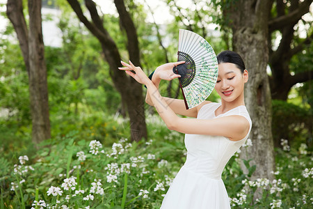 舞动扇子的年轻女性图片