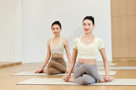 两个年轻美女瑜伽盘腿背景
