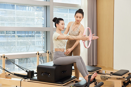 瑜伽教练指导女生健身环训练图片