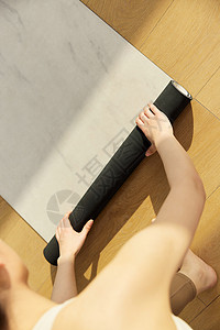 运动美女整理瑜伽垫图片