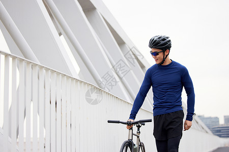 推着自行车走路的年轻男性背景图片
