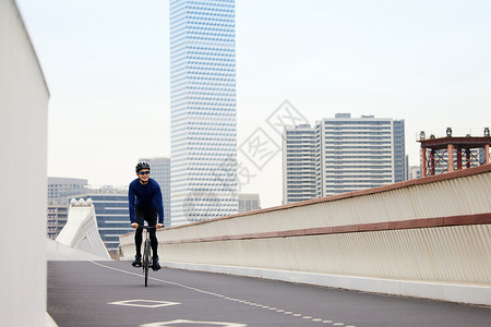天桥上热爱骑行的男性背景图片
