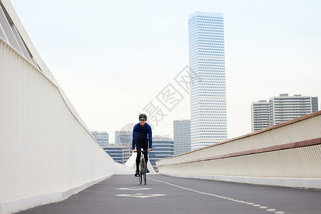 天桥上热爱骑行的男性背景图片
