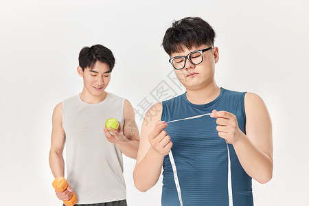 手拿软尺的肥胖男性与肌肉男背景图片