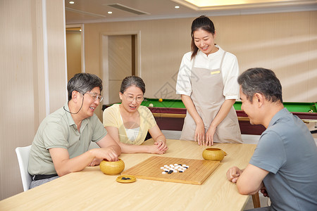 围棋活动素材活动室里陪同老人玩围棋的护工背景