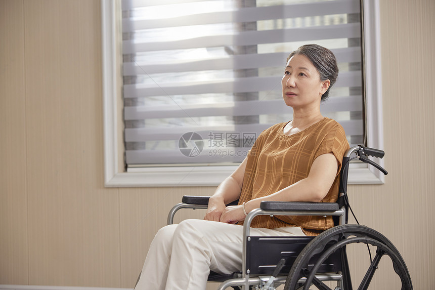 坐在轮椅上忧愁的中老年女性图片