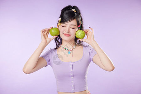 紫色的牛油果可爱女生手中的青苹果背景