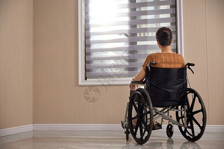 残疾人物坐在轮椅望着窗外的老人背影背景