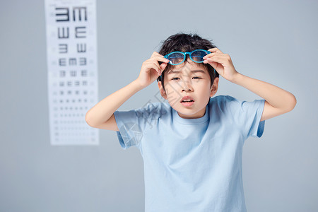 健康用眼近视的小男孩在检查视力背景