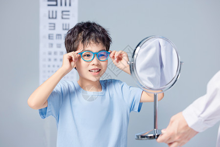 蒙着眼睛开心的戴着眼镜做检查的儿童背景