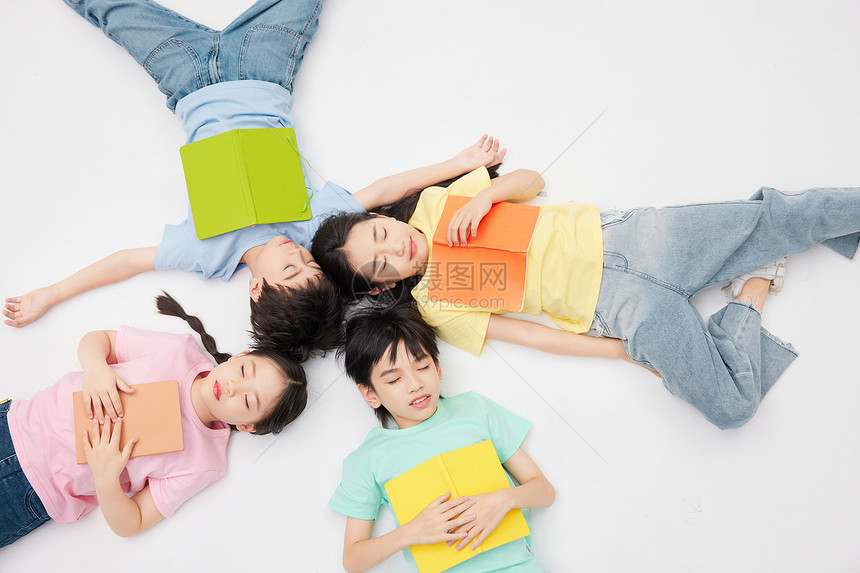 儿童四人抱着书本睡着图片