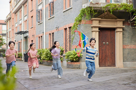 四个小男孩儿童小朋友户外追着风筝奔跑背景