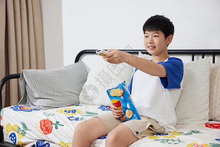 看电视的男生居家吃零食看电视的男孩背景