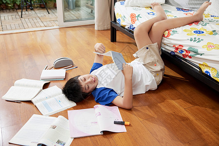 躺在枫叶上读书躺在地板上看书的男孩背景