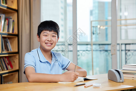 小学生形象写作业的男孩微笑形象背景