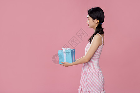 双十一狂欢购物女性侧面手拿礼物盒背景