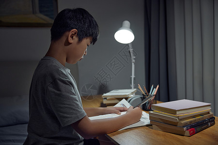 台灯看书书房里熬夜学习的小学生形象背景