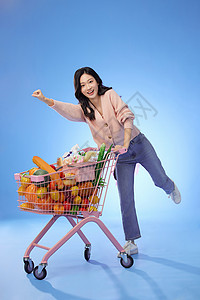 推着装满蔬菜的购物车的女性图片