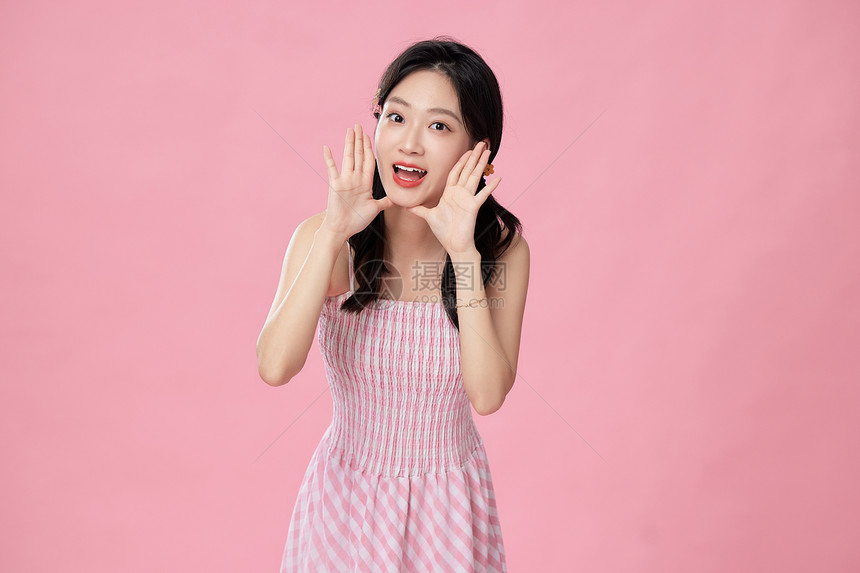 穿粉色裙子的美女开心地举手呼喊图片