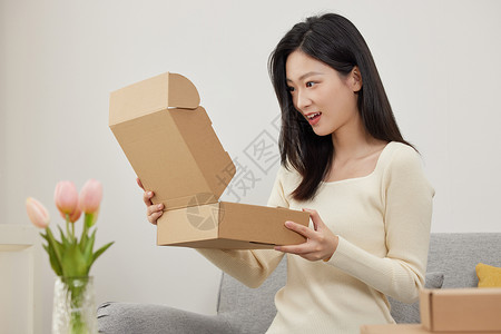 开心地打开快递盒的女生背景图片