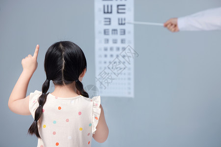 眼痒小女孩在医生指导下做视力测试背景
