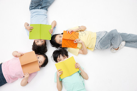四个小朋友手拿书本躺在地上男孩高清图片素材