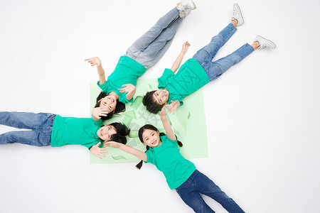 四个小男孩小朋友们一起躺在绿色环保标志上背景