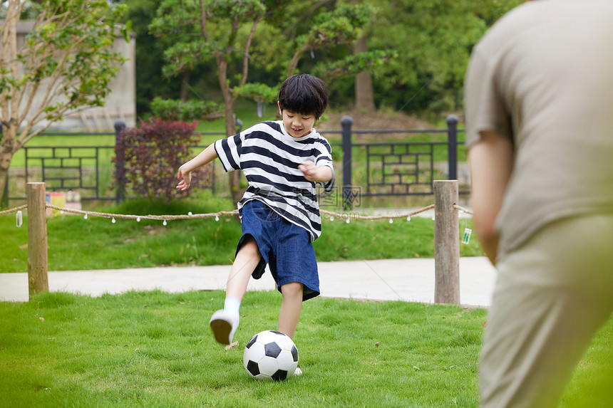 一起在草坪上玩足球的父子图片