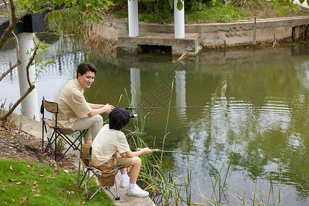 爸爸在湖边和儿子钓鱼聊天图片