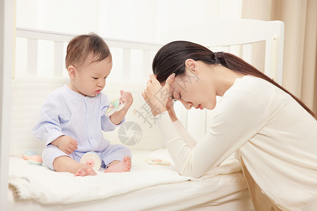 疲惫的妈妈和婴儿床里的宝宝背景图片