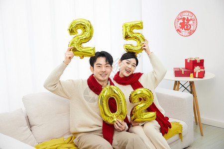 中国风情侣高举2025数字的居家年轻情侣背景