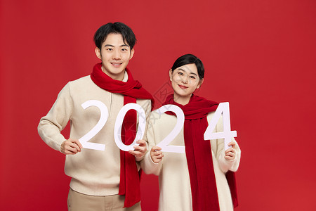龙年春节幸福年手拿数字2024的年轻情侣背景