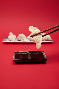 筷子夹起水饺蘸醋特写背景图片