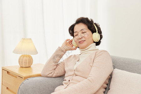 女性听音乐在沙发上听音乐的中年女性背景