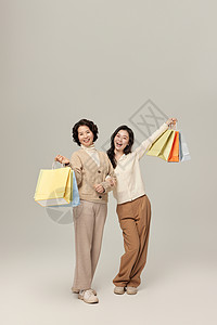 时尚家人母女拎购物袋逛街背景
