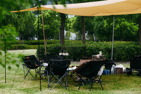 夏天帐篷草地上的户外露营装备背景
