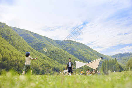爸爸和儿子在草坪上玩飞盘高清图片