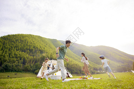 暑假期间一家人在草地上奔跑背景