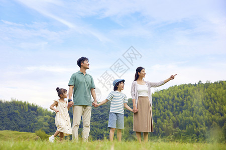 站在书上的孩子一家四口站在草地上散步背景