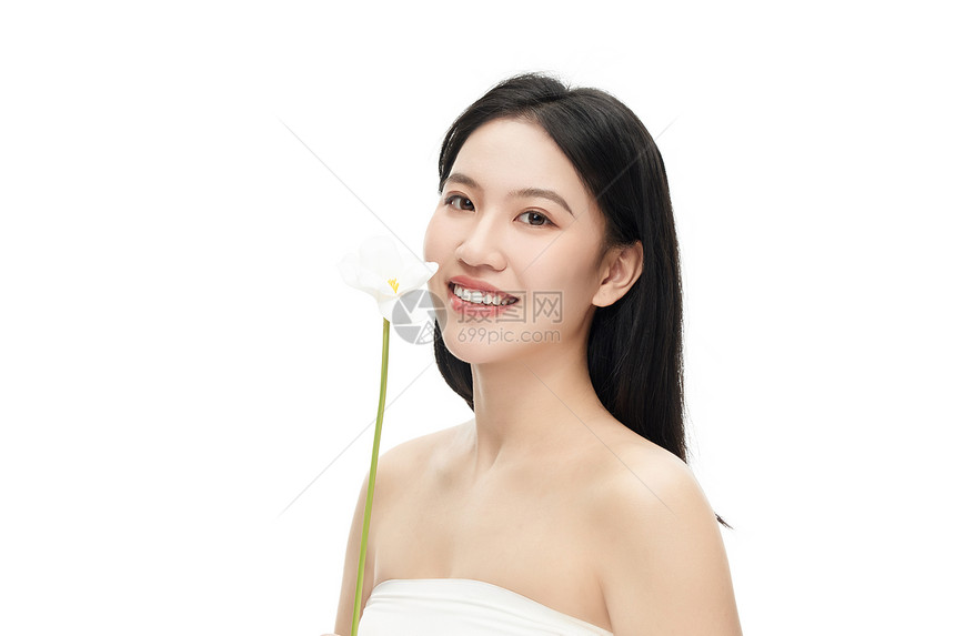 专业模特将花放置鼻子前微笑摆拍图片