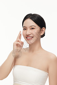 面霜护肤正准备把手上面霜涂抹至脸上的气质女人背景