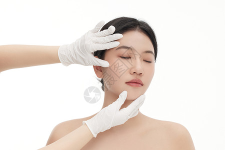 塑形镜整形医生用双手触摸确定女人脸部状态背景