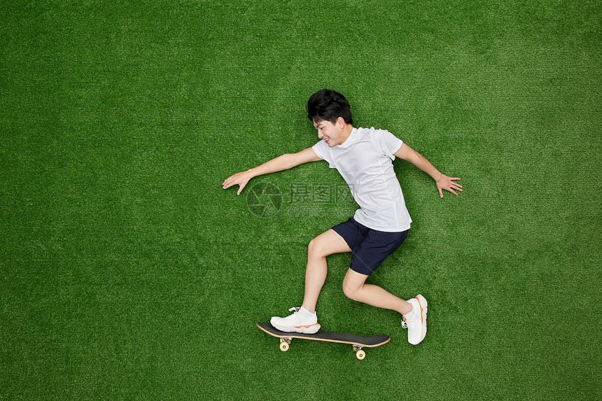 创意俯拍正在滑滑板的青春少年图片