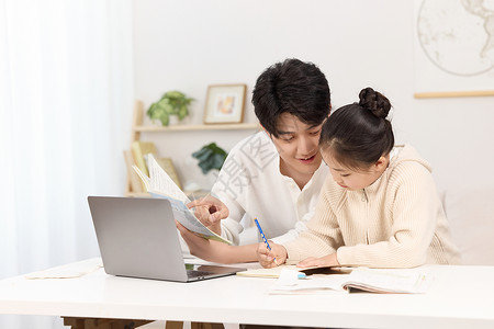 儿童学习新知识正辅导女儿完成作业的年轻爸爸背景