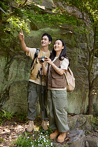 徒步旅行的年轻情侣拿相机拍摄高清图片