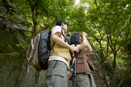 旅行欢乐徒步登山的年轻情侣看向远方背景